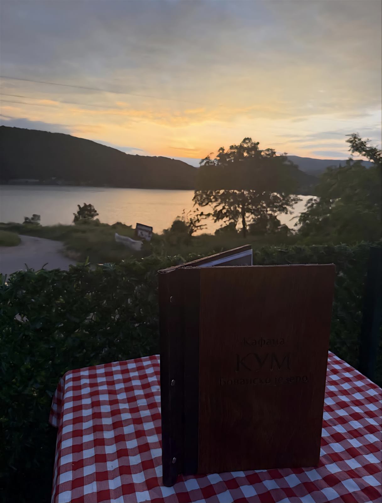 Meni Kafane Kum na stolu, uz pogled na jezero u sumrak